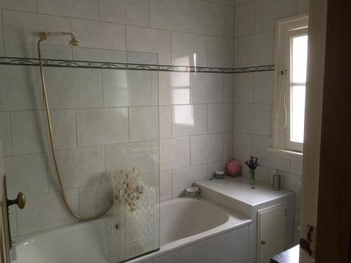 une salle de bain blanche avec une baignoire et un lavabo dans l'établissement BnB at Bidwill, à Wellington