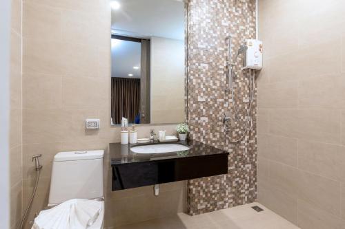 a bathroom with a sink and a toilet and a mirror at Utopia Kata in Kata Beach