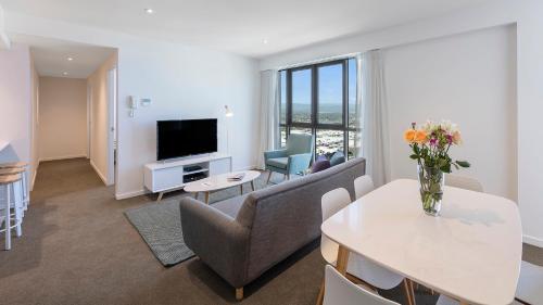 a living room filled with furniture and a tv at Avani Broadbeach Residences in Gold Coast