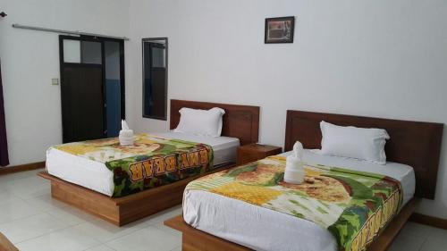 two beds in a room with two at Jo Homestay in Selong Belanak