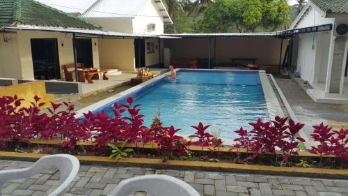 a swimming pool in a house with a person in it at Jo Homestay in Selong Belanak