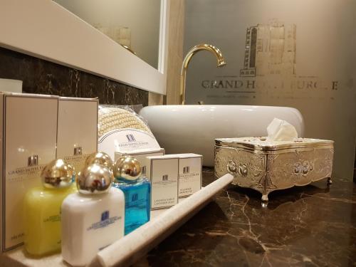 a bathroom with a sink and a counter top withentedented products at Grand Hotel Europe in Baku