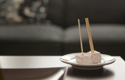 two pieces of sushi on a plate with chopsticks at Myrtiana Apartments in Nicosia