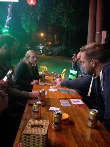 a group of people sitting around a wooden table at Ngan Ha Homestay in Ha Giang