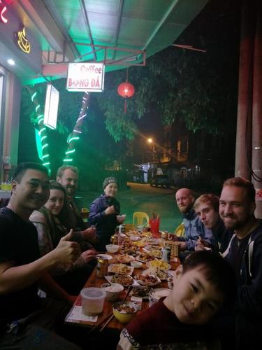 a group of people sitting around a table eating food at Ngan Ha Homestay in Ha Giang