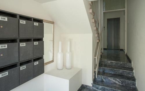 a hallway with white walls and a staircase with white vases at Myrtiana Apartments in Nicosia