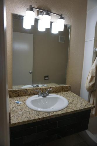 a bathroom counter with a sink and a mirror at Econo Lodge San Antonio Northeast I-35 in San Antonio