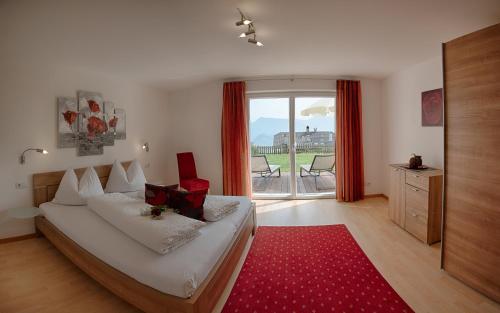 a bedroom with a bed and a red rug at Residence Prunarhof in Caldaro