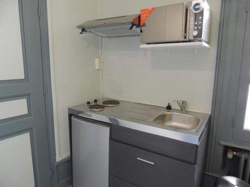 a small kitchen with a sink and a microwave at Appartement Le Gambetta in Le Mans