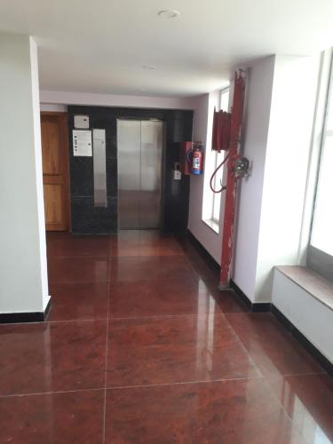 an empty hallway with a tile floor in a building at Hotel Abhilasha in Giriak