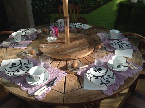 a wooden table with a table set with plates and cups at Maison du Théâtre Saint Bonnet in Bourges