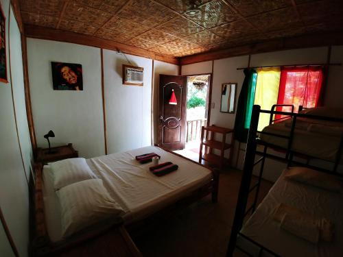 a bedroom with a bed and a room with two bunk beds at Reggae Guesthouse in Panglao