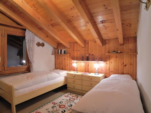 2 camas en una habitación con paredes de madera en Cosy 3.5 pièce à Täsch, en Täsch