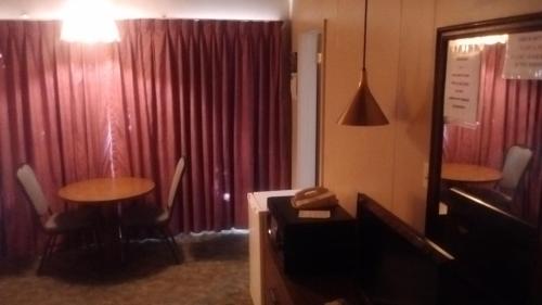 a room with two tables and a red curtain at Cedar Inn in McCook