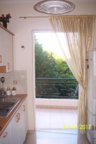 a kitchen with a window with a view of a balcony at Quiet spacious apartment in Nafplio in Nafplio