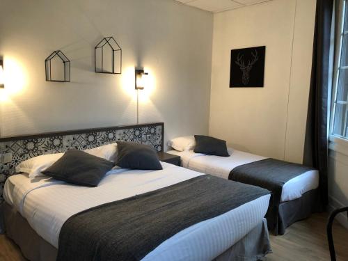 a hotel room with two beds and lights on the wall at Les Initiés in Rouen