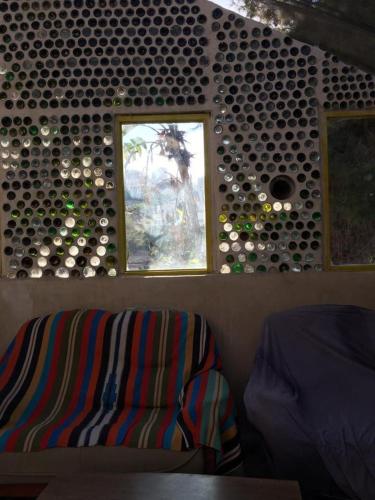 a room with a couch and a window and a wall of wine bottles at Hosh Al Subbar in Bethlehem