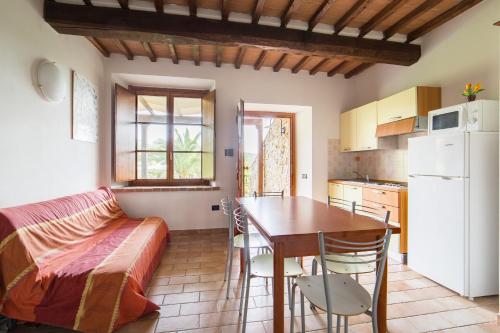 a kitchen and dining room with a table and a bed at Agriturismo e Glamping Serraiola Alta in Frassine