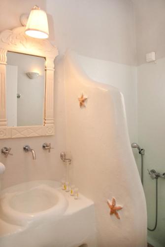 a bathroom with a sink and two starfish on the wall at Altana Boutique Hotel in Tinos Town