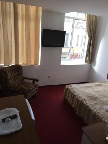 Una televisión o centro de entretenimiento en Hotel Rares