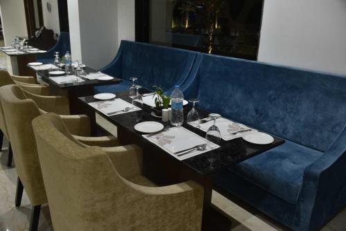 a table in a restaurant with a blue couch at Pride Hotel & Convention Centre Indore in Indore