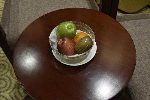 a bowl of fruit sitting on top of a table at Pride Hotel & Convention Centre Indore in Indore