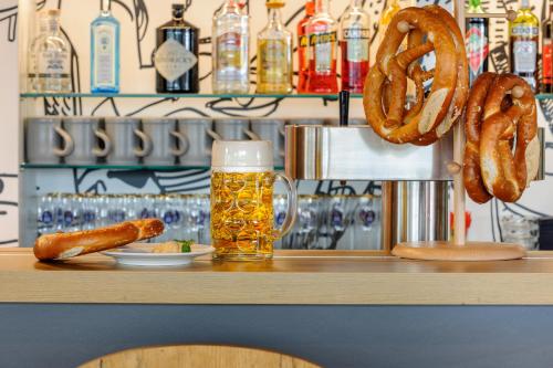 a bar with a glass of beer and a pretzel at ibis Hotel München Messe in Feldkirchen