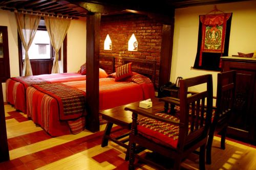 a bedroom with a bed and a chair in it at Temple House in Kathmandu