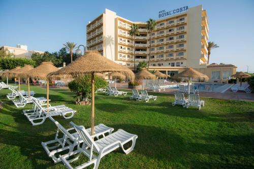 a group of lounge chairs and umbrellas in a park at BLUESEA Costa Serena in Torremolinos