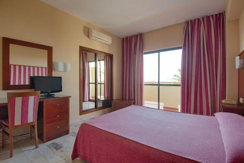 Dormitorio con cama, escritorio y TV en Royal Costa, en Torremolinos
