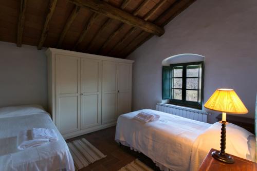 a bedroom with two beds and a lamp on a table at Casa Marina in Greve in Chianti