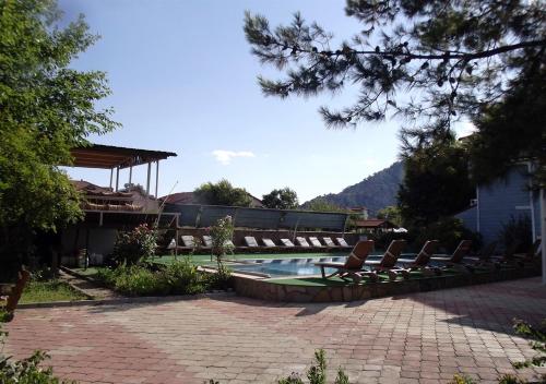 a swimming pool with lounge chairs next to a house at Gurkan Apart Hotel in Dalyan