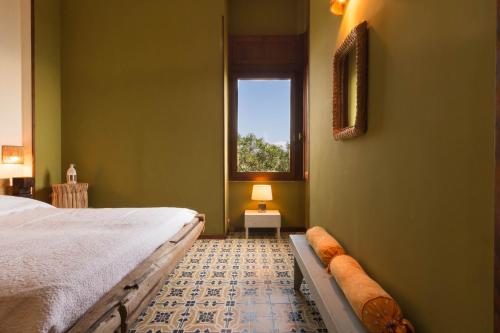クアルトゥ・サンテーレナにあるLa Villa di Cala Reginaの緑のベッドルーム(ベッド1台、窓付)