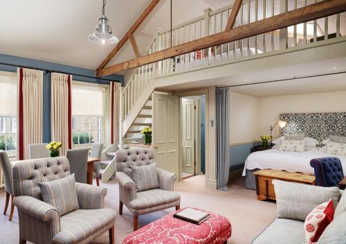 a bedroom with a large bed and a staircase at The Pelham London - Starhotels Collezione in London