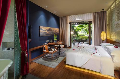 a bedroom with a large bed and a bathroom at Angsana Hangzhou in Hangzhou