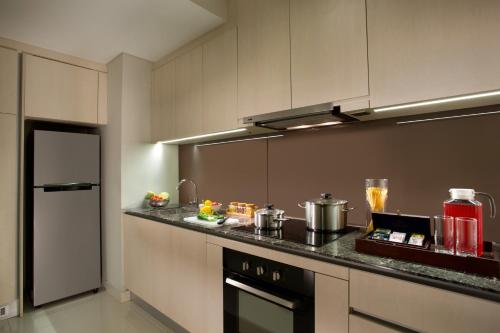 a kitchen with a counter top with a stove at Ascott Waterplace Surabaya in Surabaya