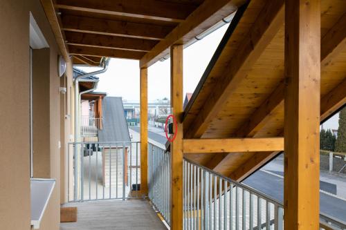 a wooden balcony with a wooden roof with a view of a street at Design-Apartments Graz in Graz