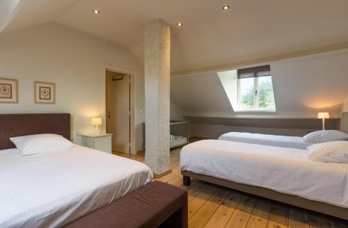 a bedroom with two beds and a window at Le Coeur des Choses in Escalles