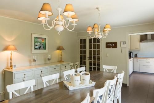 a kitchen and dining room with a table and chairs at Le Coeur des Choses in Escalles