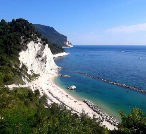 a beach with a group of people on the shore at Viverenumana appartamenti la tua casa in centro a pochi passi dal mare in Numana