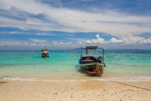 two boats in the water on a beach at The Cove Phi Phi in Phi Phi Don