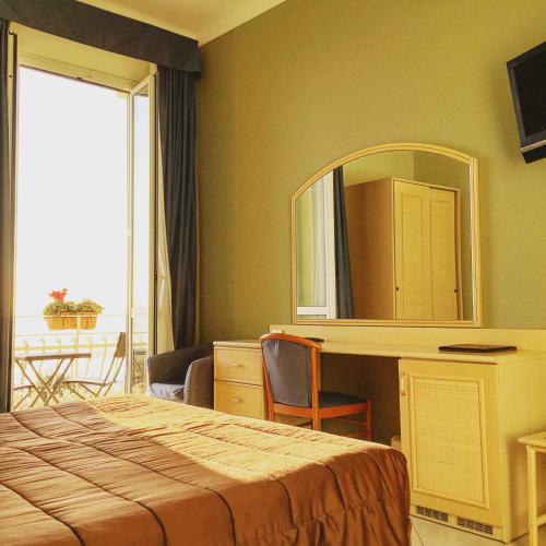 a hotel room with a bed and a mirror at Hotel Villa Igea in Alassio