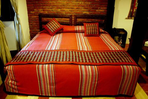 a red bed with two pillows on top of it at Temple House in Kathmandu