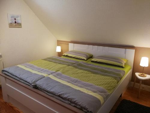ein Bett in einem Schlafzimmer mit zwei Kissen darauf in der Unterkunft Haus Sommerwind in Norderney