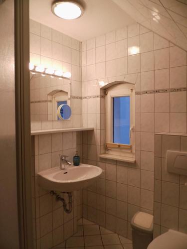 Un baño con lavabo, inodoro y ventana. en Apartments Haus Eintracht Sellin, en Ostseebad Sellin