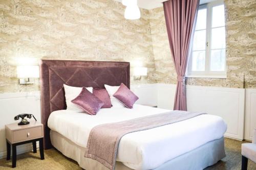 a bedroom with a large bed with purple pillows at Les Jardins d'Epicure in Bray-et-Lû