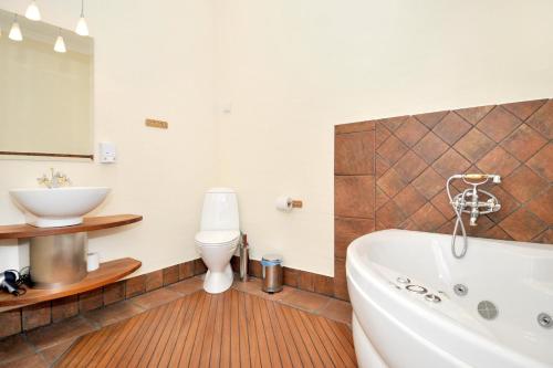 a bathroom with a tub and a toilet and a sink at Best Bed in Herning