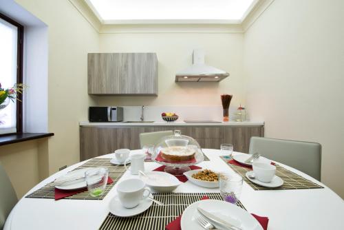 a dining room table with white plates and bowls of food at Costa di Bussia in Monforte dʼAlba