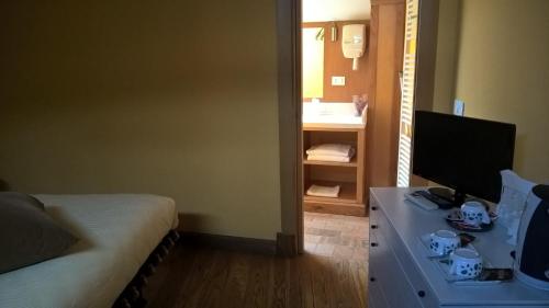 a room with a bed and a desk with a television at Grancia dei Celestini in Sulmona