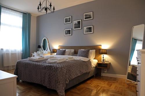 Schlafzimmer mit einem Bett und einem Wandspiegel in der Unterkunft Grey Apartments Kościuszko in Krakau